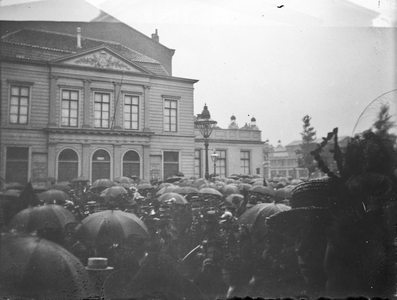 832218 Afbeelding van het publiek tijdens een optocht of gebeurtenis (in de regen) ter hoogte van de Stadsschouwburg op ...